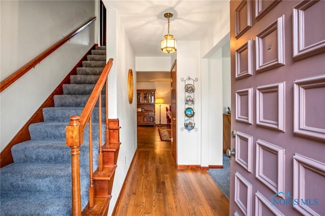 entrance foyer featuring baseboards, wood-type flooring, and stairs