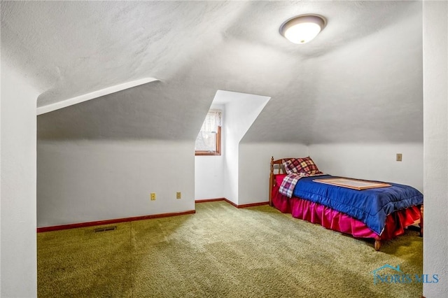 carpeted bedroom featuring visible vents, a textured ceiling, baseboards, and vaulted ceiling