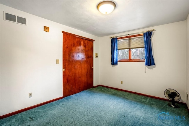 empty room with baseboards, visible vents, and carpet floors