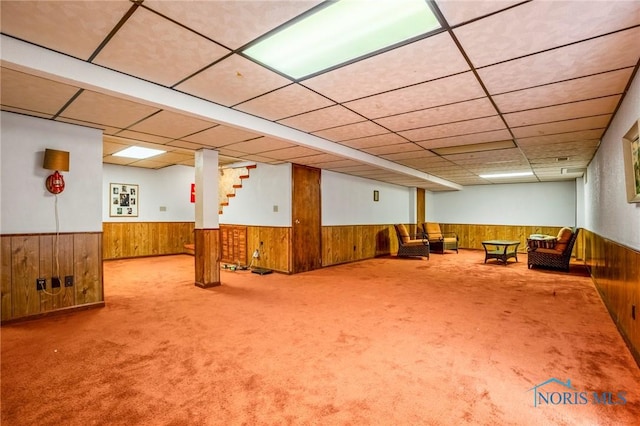 interior space with a wainscoted wall and wooden walls