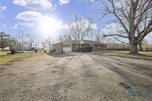 view of front of house with a garage, brick siding, and driveway