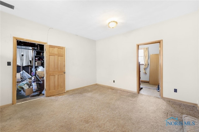 unfurnished bedroom featuring visible vents, carpet, baseboards, and ensuite bathroom