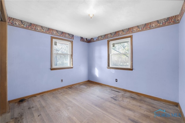 unfurnished room with wood finished floors and baseboards