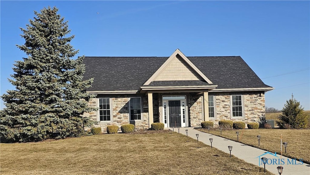 craftsman-style house with a front yard and stone siding