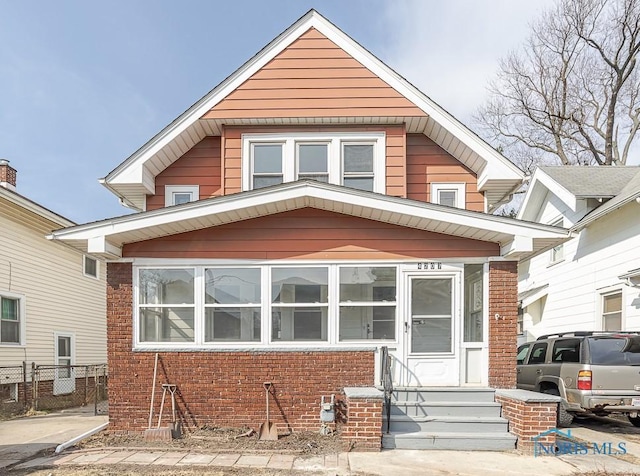 view of front of home with brick siding and fence