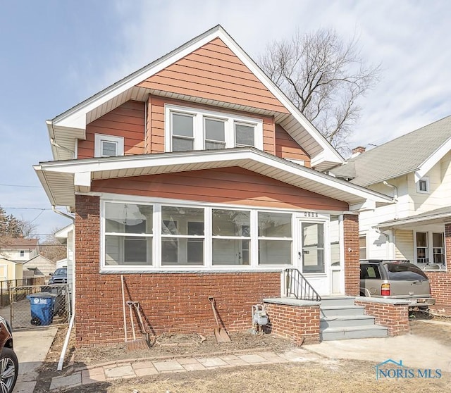 view of front of property with brick siding and fence