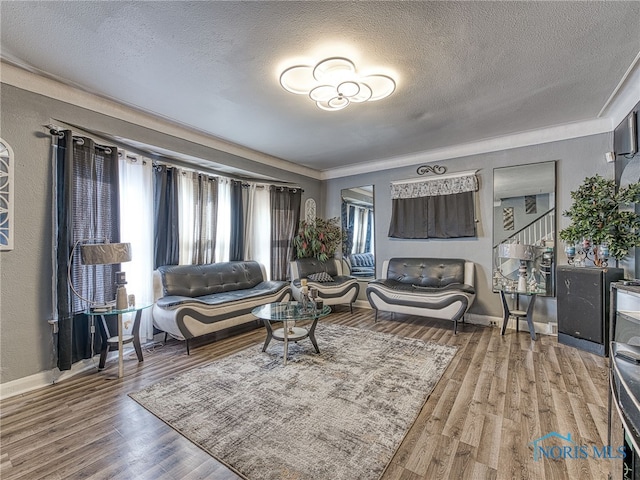 living area featuring a textured ceiling, baseboards, and wood finished floors