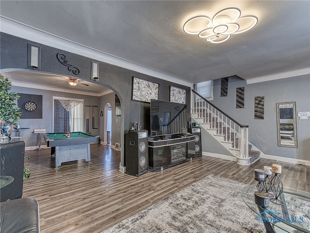 recreation room featuring a textured ceiling, wood finished floors, arched walkways, pool table, and baseboards