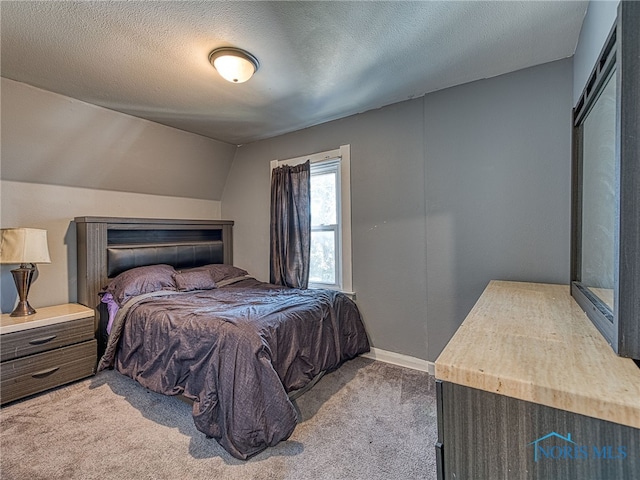 bedroom with baseboards, a textured ceiling, carpet flooring, and vaulted ceiling