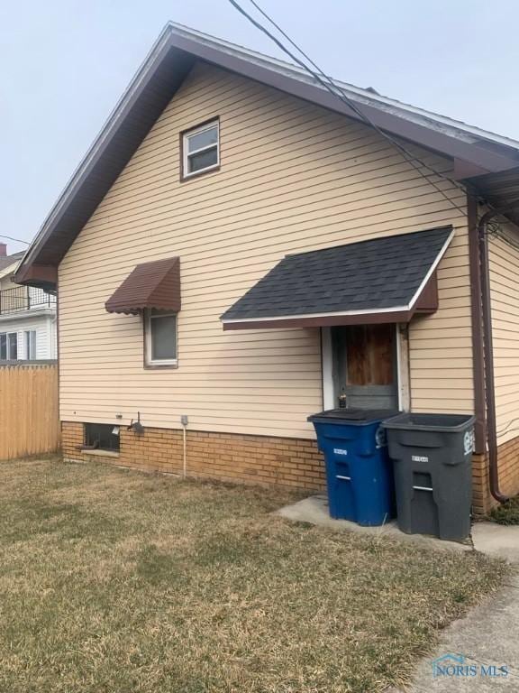 view of side of home featuring a yard and fence