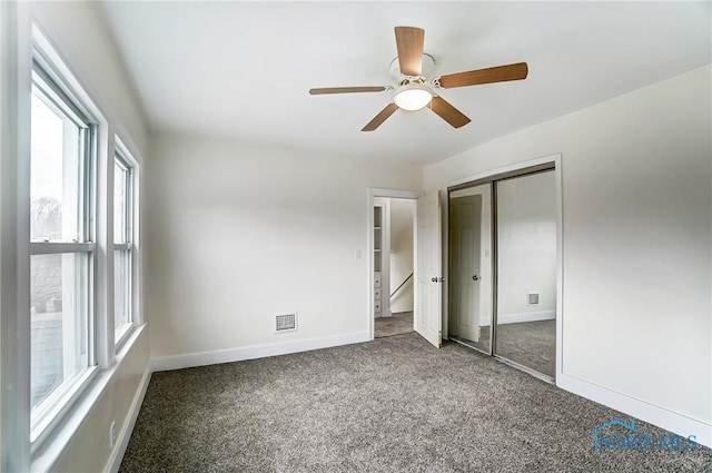 unfurnished bedroom with visible vents, a ceiling fan, a closet, carpet floors, and baseboards