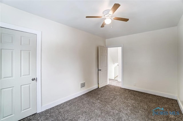 unfurnished bedroom featuring a ceiling fan, baseboards, visible vents, and dark carpet