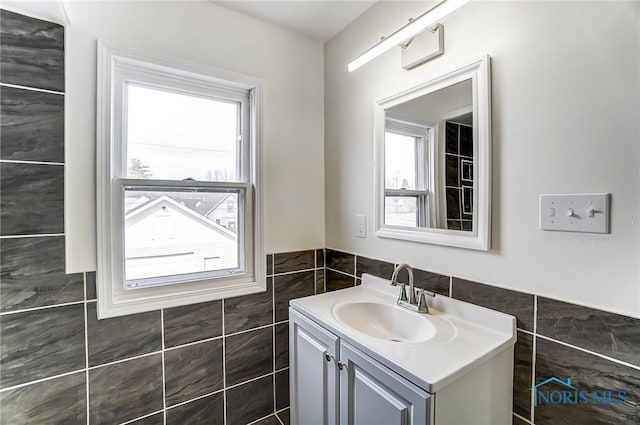 bathroom with vanity and tile walls