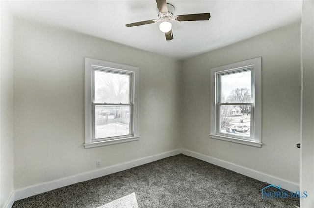 1488 Gould Rd, Toledo, OH 43612 - unfurnished room featuring dark carpet, baseboards, and a wealth of natural light