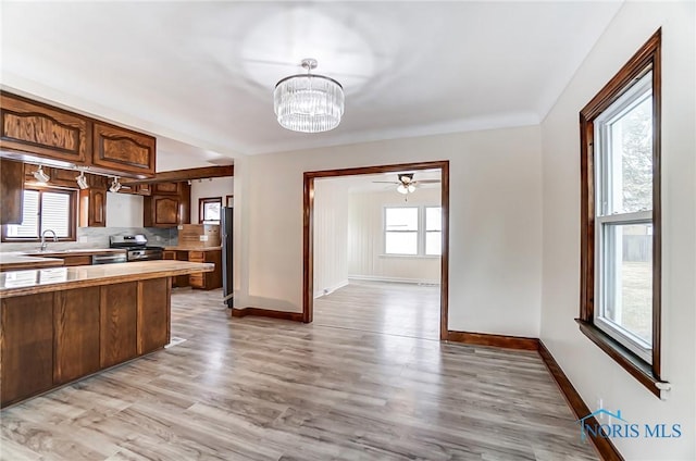 kitchen with plenty of natural light, appliances with stainless steel finishes, light wood-style flooring, and light countertops