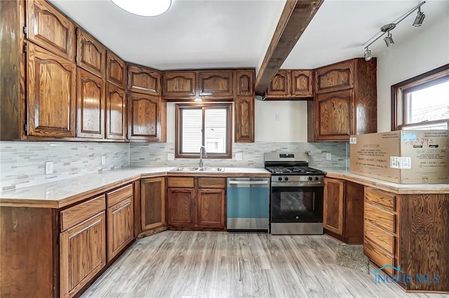 kitchen with light countertops, plenty of natural light, appliances with stainless steel finishes, and a sink