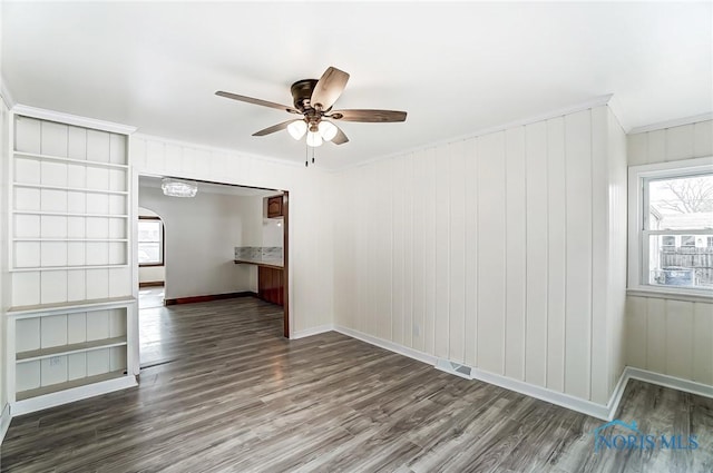 unfurnished living room featuring wood finished floors, baseboards, visible vents, arched walkways, and ceiling fan