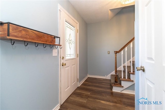 interior space featuring stairway, baseboards, and dark wood-style floors