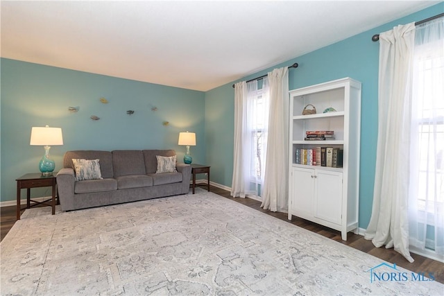 living area featuring baseboards and wood finished floors