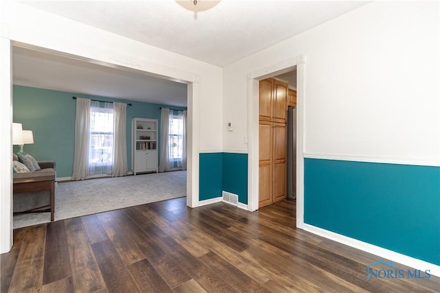 spare room with visible vents, dark wood-type flooring, and baseboards