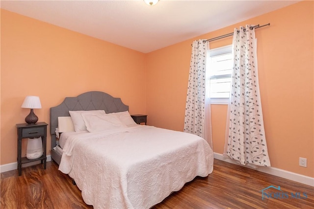 bedroom featuring wood finished floors and baseboards