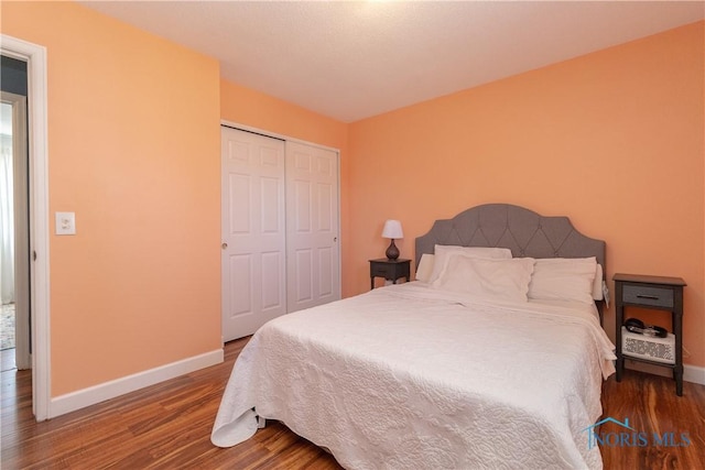 bedroom featuring a closet, baseboards, and wood finished floors