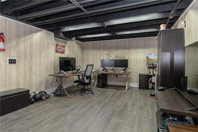 office area featuring wood finished floors, baseboards, and wood walls