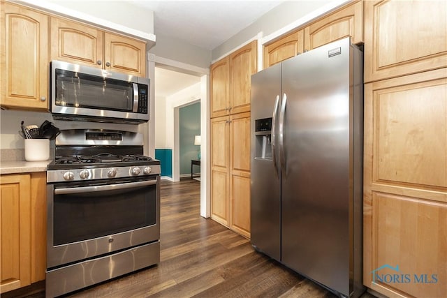 kitchen featuring light brown cabinets, baseboards, dark wood-style flooring, light countertops, and appliances with stainless steel finishes