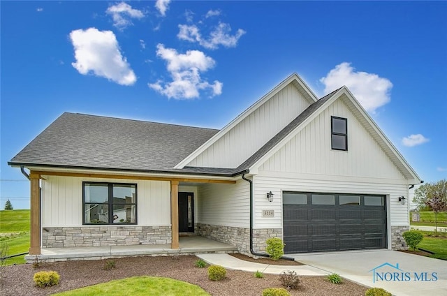 5224 Rail St, Monclova, OH 43542 - modern inspired farmhouse with driveway, stone siding, a porch, a shingled roof, and a garage