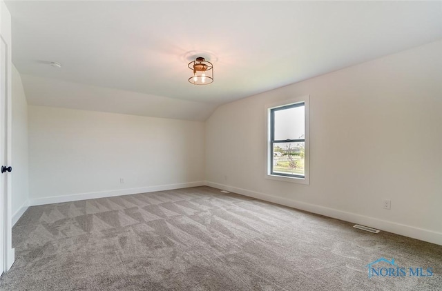 5224 Rail St, Monclova, OH 43542 - spare room with visible vents, carpet floors, baseboards, and vaulted ceiling