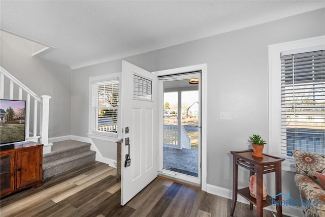 entryway featuring stairway, baseboards, and dark wood-type flooring