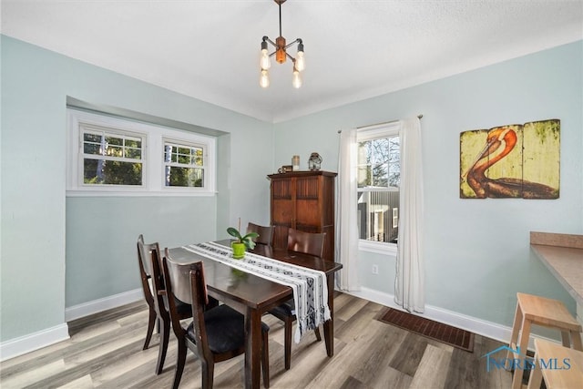 dining room with an inviting chandelier, wood finished floors, and baseboards