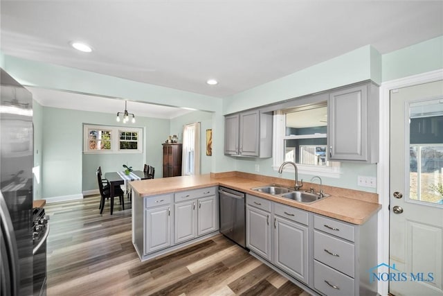 kitchen with dishwasher, a peninsula, gray cabinetry, and a sink