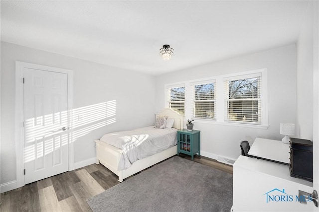 bedroom featuring visible vents, baseboards, and wood finished floors