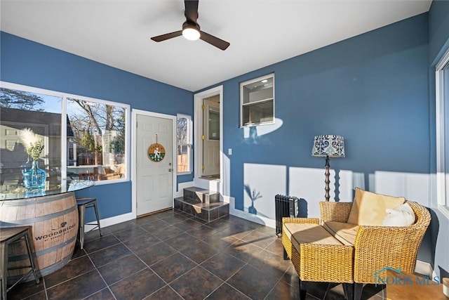 sitting room with baseboards and a ceiling fan