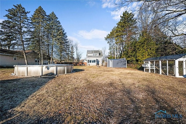 view of yard featuring an outbuilding, exterior structure, and a covered pool