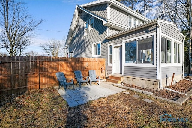 back of house featuring entry steps, a patio, and fence