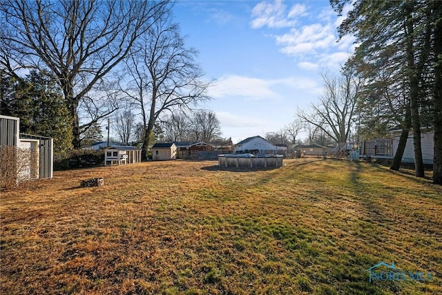 view of yard with a covered pool and fence