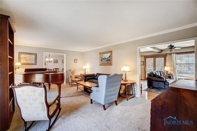 living room featuring carpet floors, a ceiling fan, and ornamental molding