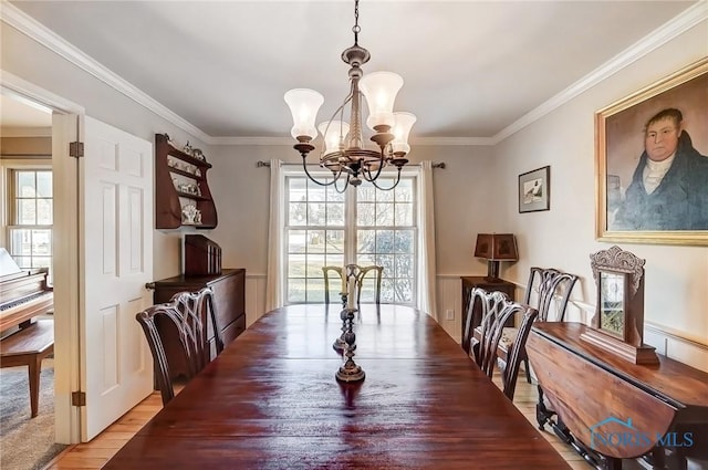 dining area featuring crown molding, a notable chandelier, and a healthy amount of sunlight