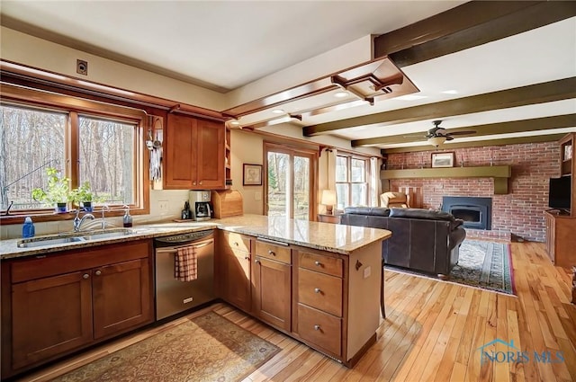 kitchen with light wood-style flooring, a sink, a peninsula, dishwasher, and ceiling fan