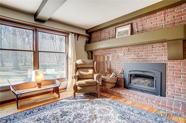 living room with heating unit, wood finished floors, baseboards, a fireplace, and beamed ceiling