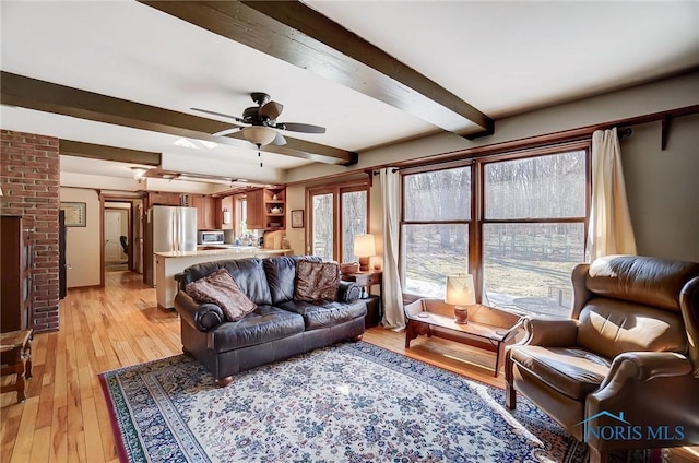 living area featuring light wood-type flooring, beam ceiling, and a ceiling fan