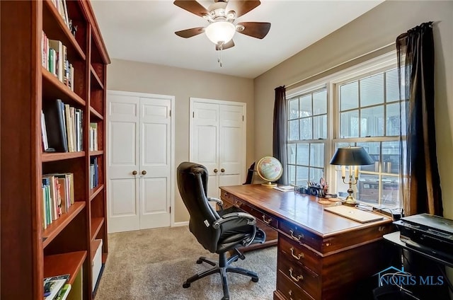 carpeted home office featuring a ceiling fan