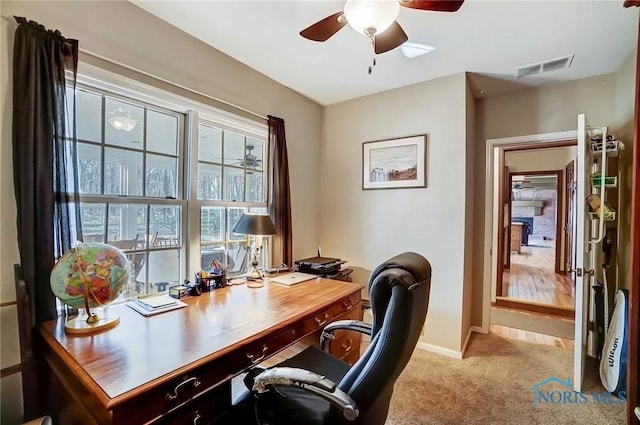 carpeted office featuring visible vents, baseboards, and a ceiling fan