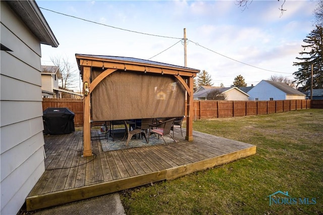 wooden deck featuring a yard, outdoor dining area, a grill, and fence private yard