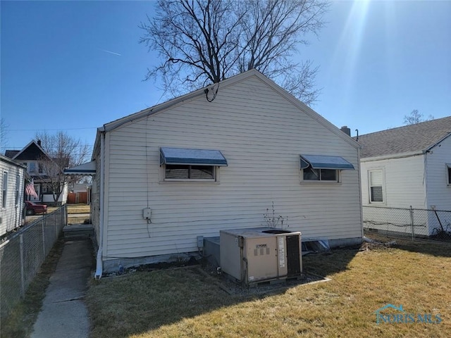 back of house with a lawn, cooling unit, and fence