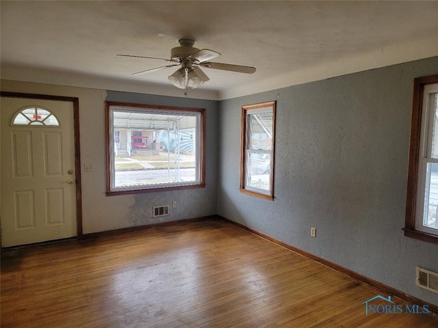 foyer entrance featuring plenty of natural light, wood finished floors, and visible vents