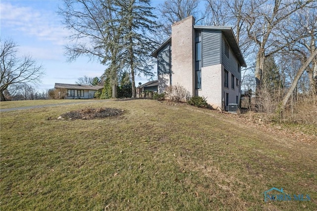 view of home's exterior with a lawn and a chimney