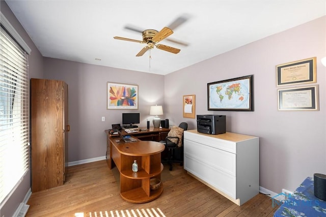 office with visible vents, baseboards, light wood-type flooring, and a ceiling fan